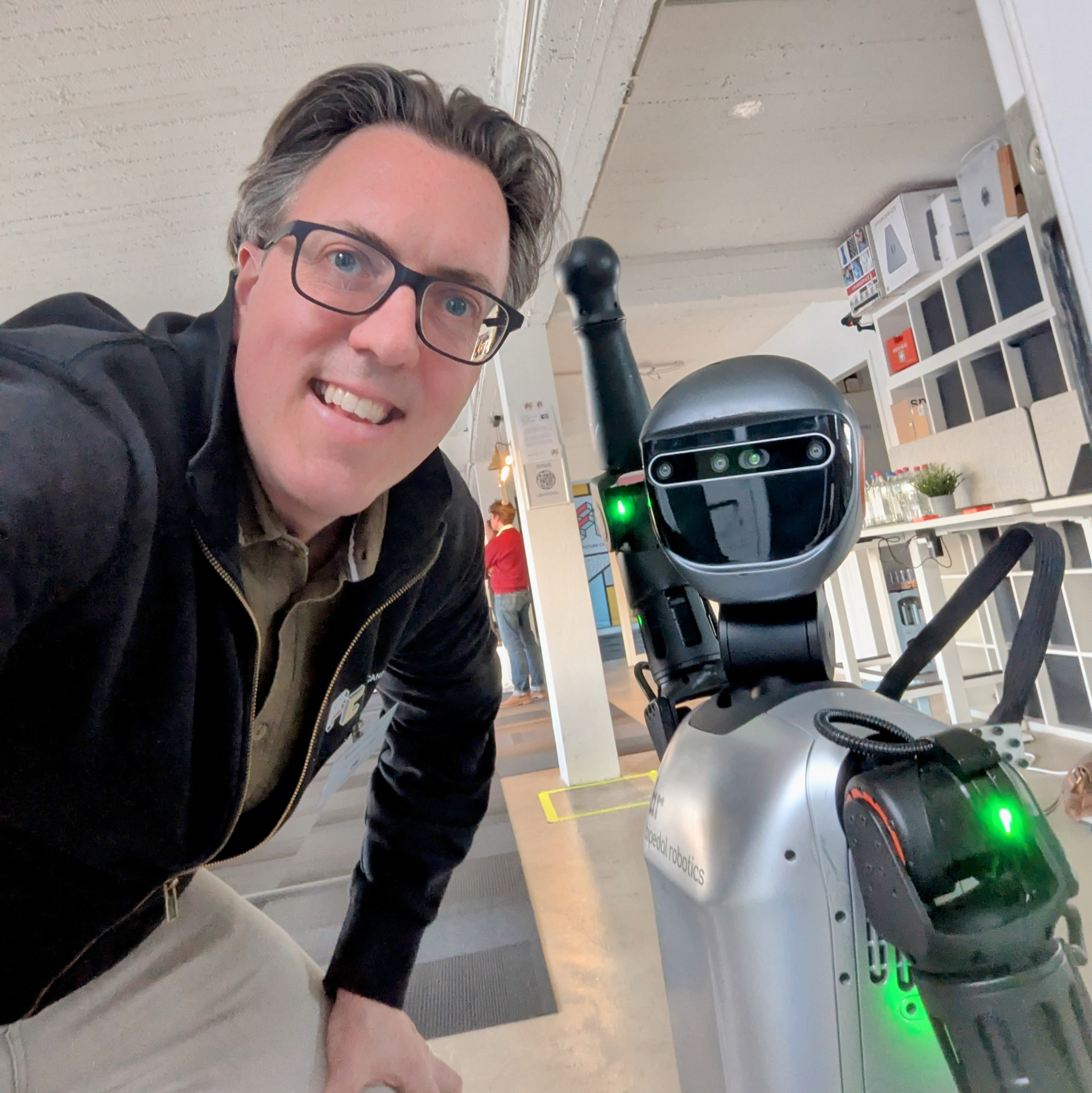 Roman Weishäupl macht ein Selfie mit einem humanoiden Roboter von Epedol Robotics