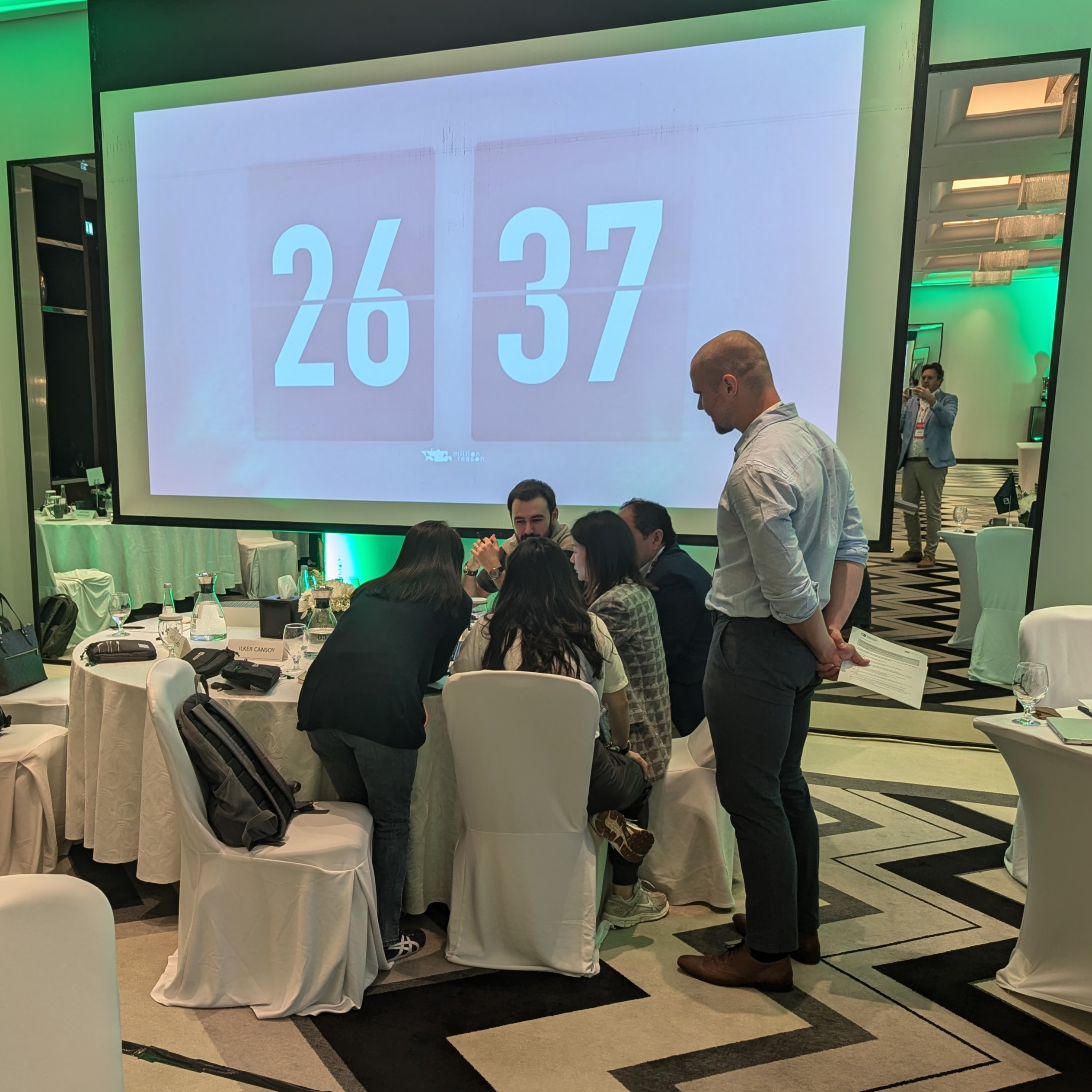 Gruppenarbeit im KI Bootcamp mit Timer auf dem Screen – Teams entwickeln KI-Lösungen