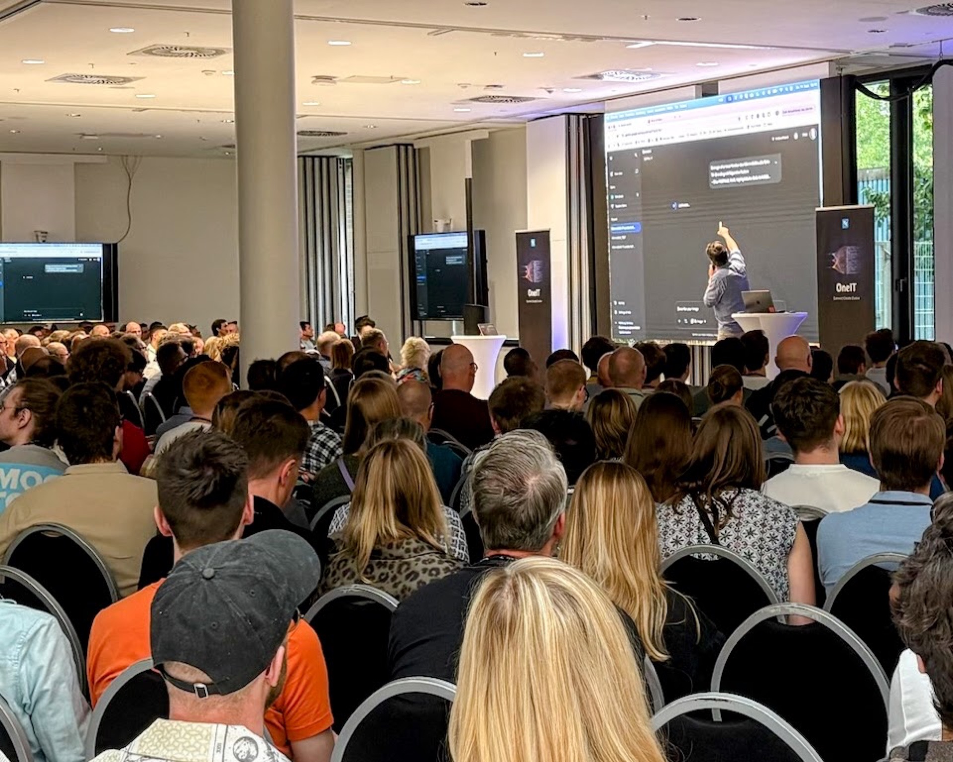 Live coding on stage at the AI Bootcamp – Roman prompts live, large audience watching