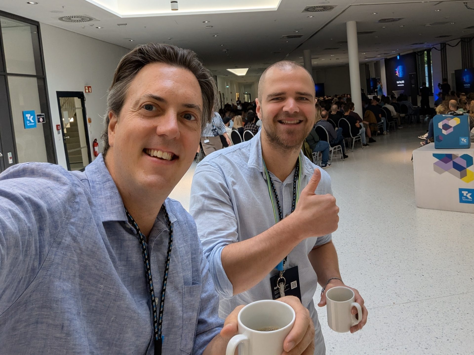 Roman Weishäupl backstage mit Kaffee, im Hintergrund das wartende Publikum