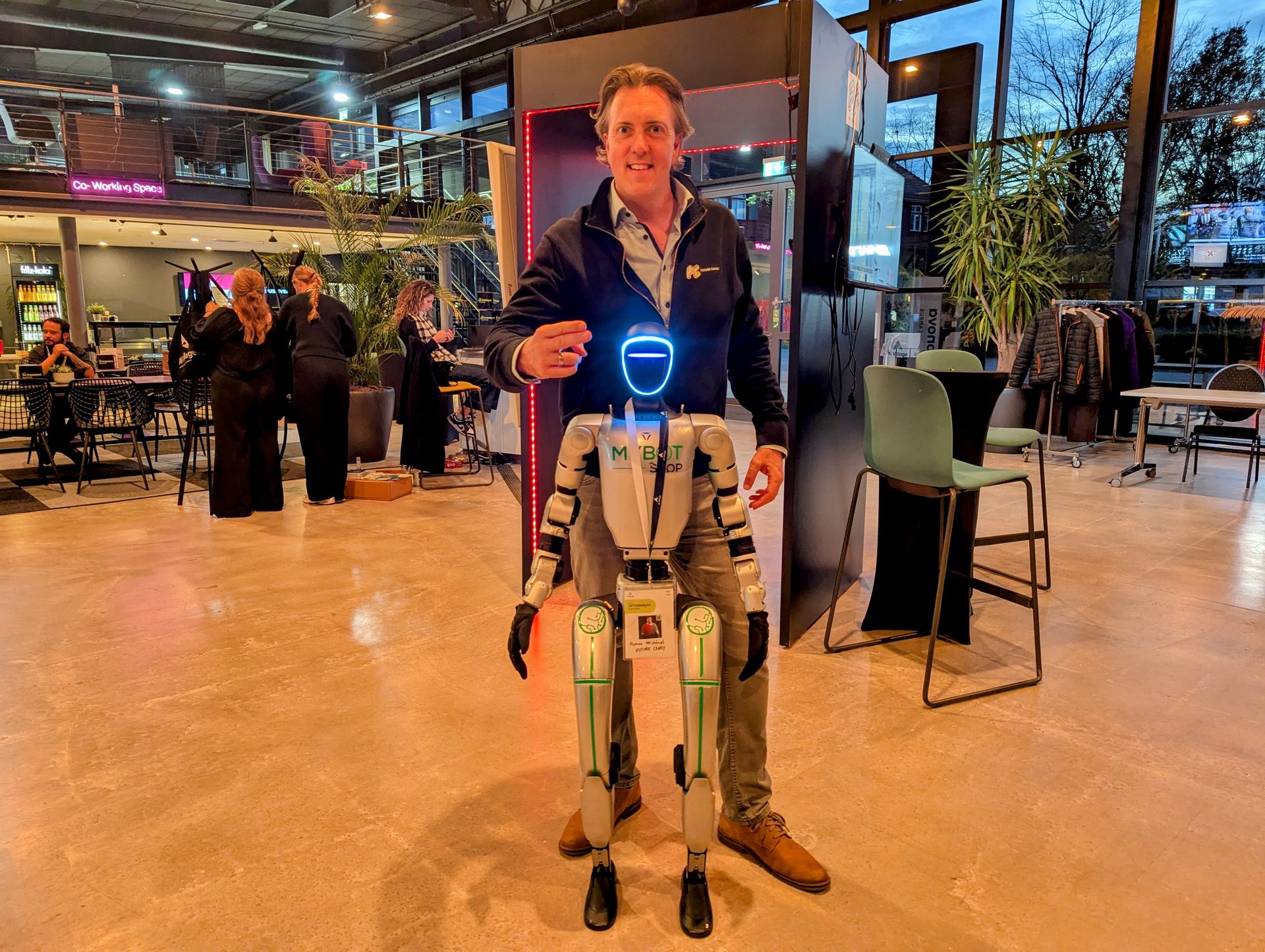 Roman Weishäupl mit einem humanoiden Roboter auf einem Innovation-Event