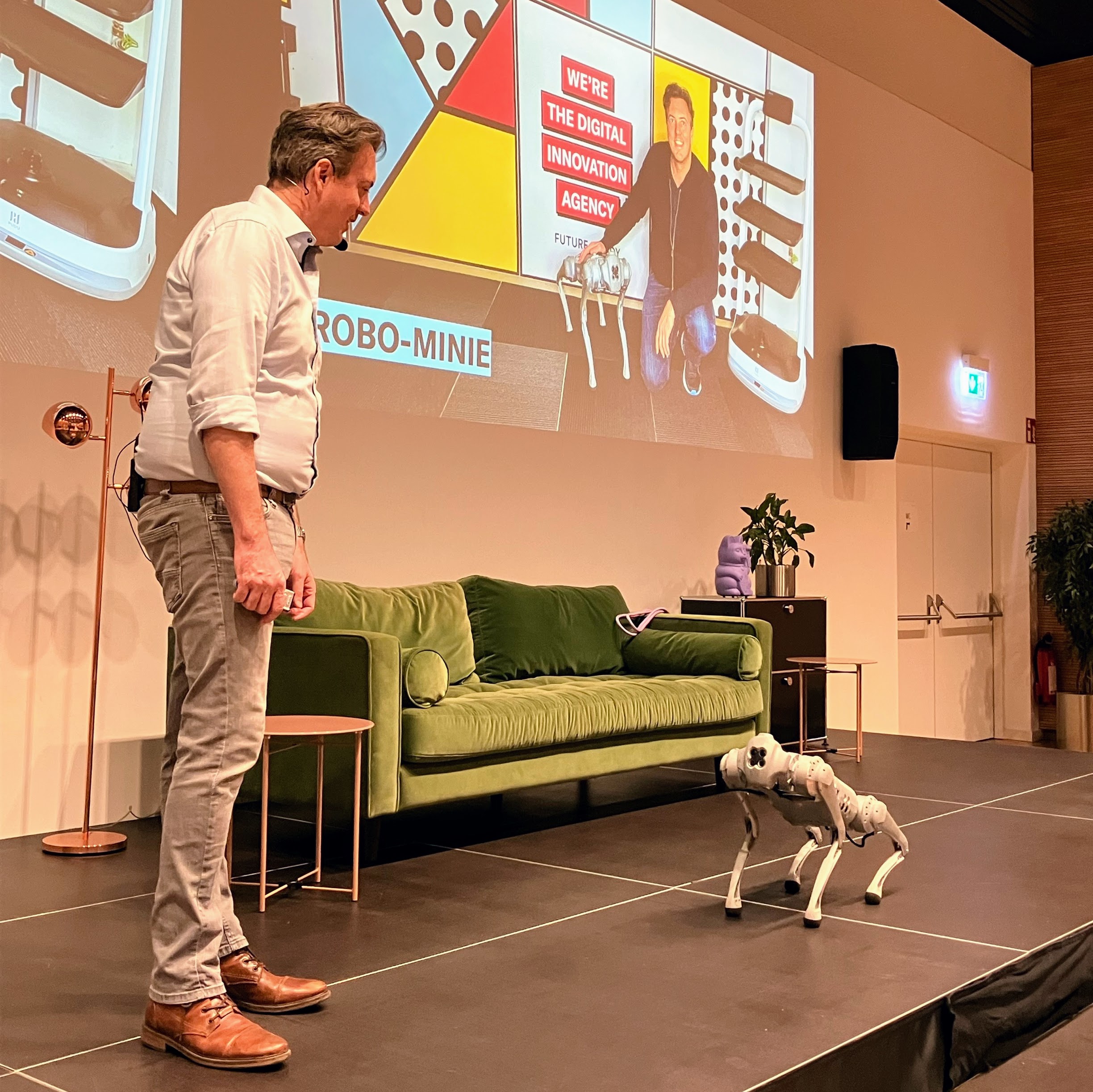 Roman Weishäupl mit Roboterhund auf der Bühne – Live-Demonstration von Robotics in der Keynote