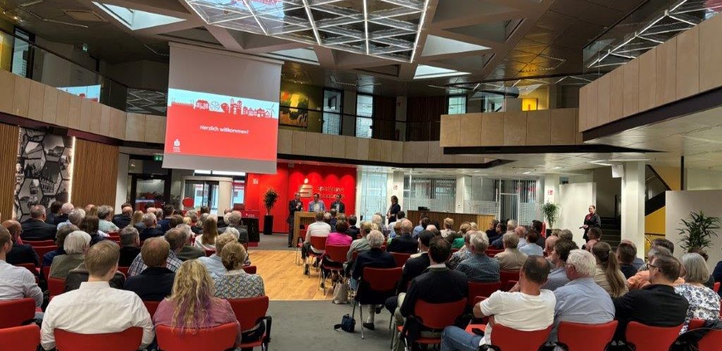 Roman Weishäupl bei einem Vortrag im Konferenzsaal, Publikum im Vordergrund